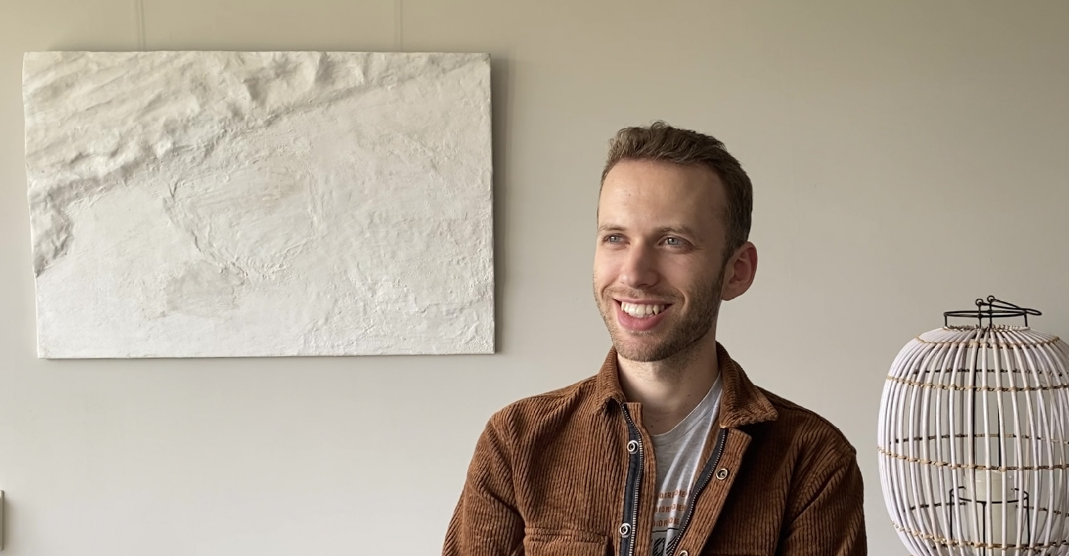 portrait en profiel van Oskar Hermans met portfolio en licht gekleurde beige en witte achtergrond en een landschap.