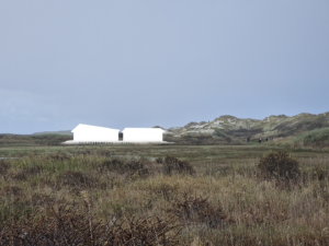 Figuur van het Delta Shelter gebouw in het landschap te zien vanuit het oosten