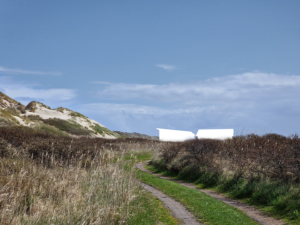 Figuur van het Delta Shelter gebouw in het landschap te zien vanuit het westen